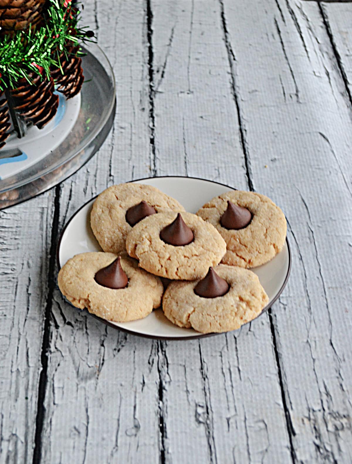 A side view of a plate of Peanut Butter Blossom Cookies.