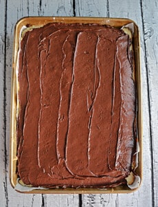 A pan of sugar cookie bars with a layer of chocolate on top.