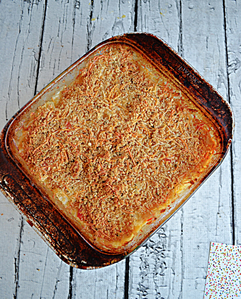 A baking dish of hash brown casserole topped with golden brown breadcrumbs. 