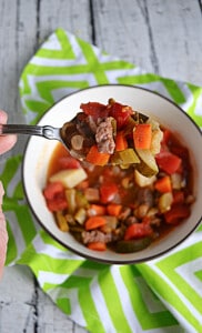 A close up of a spoon with Beef Vegetable Soup on it.