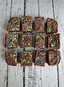 Brownies cut into 12 pieces with sprinkles on top.