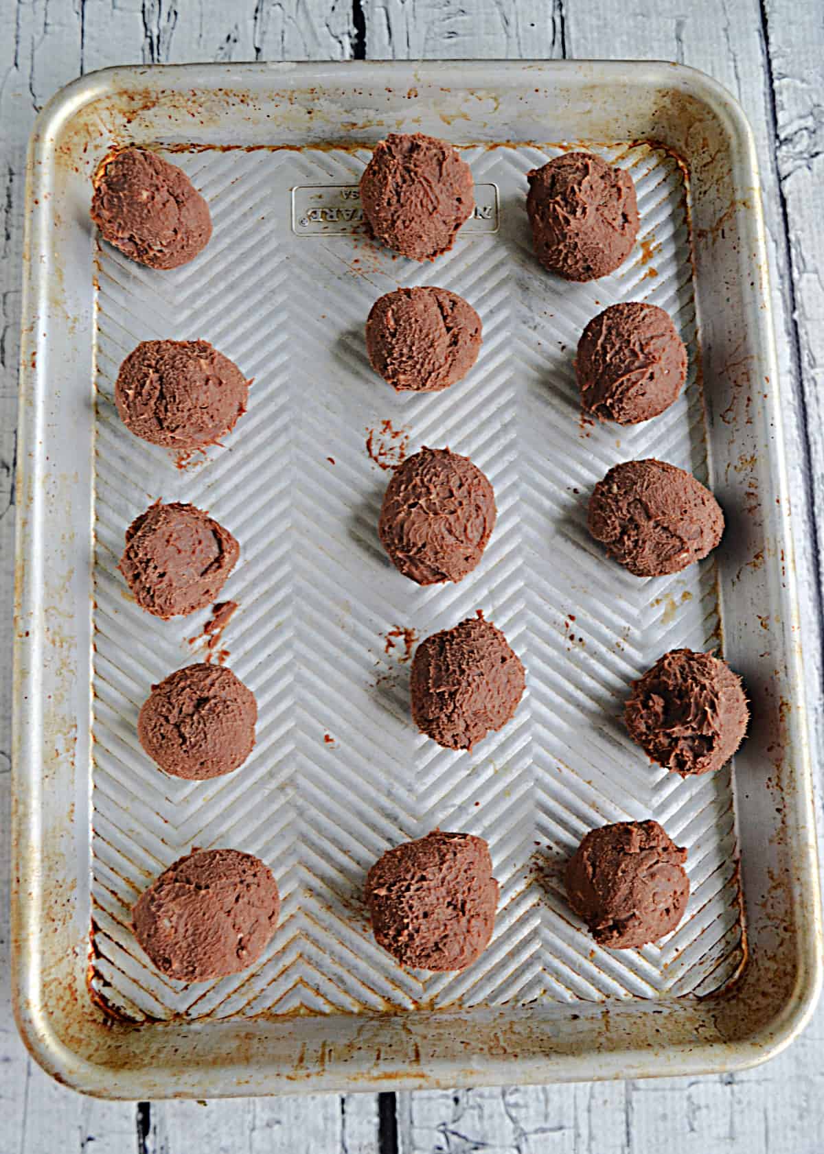 A cookie sheet with truffles on it. 
