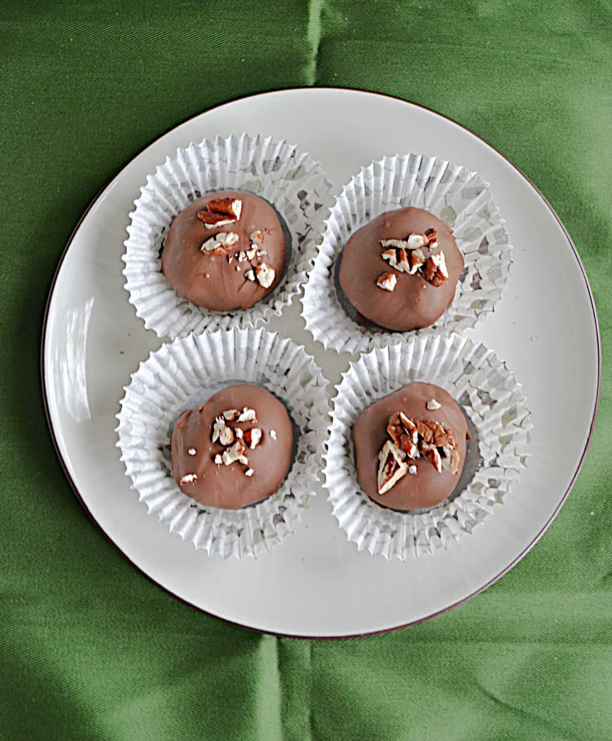 A plate with 4 truffles in cupcake liners.