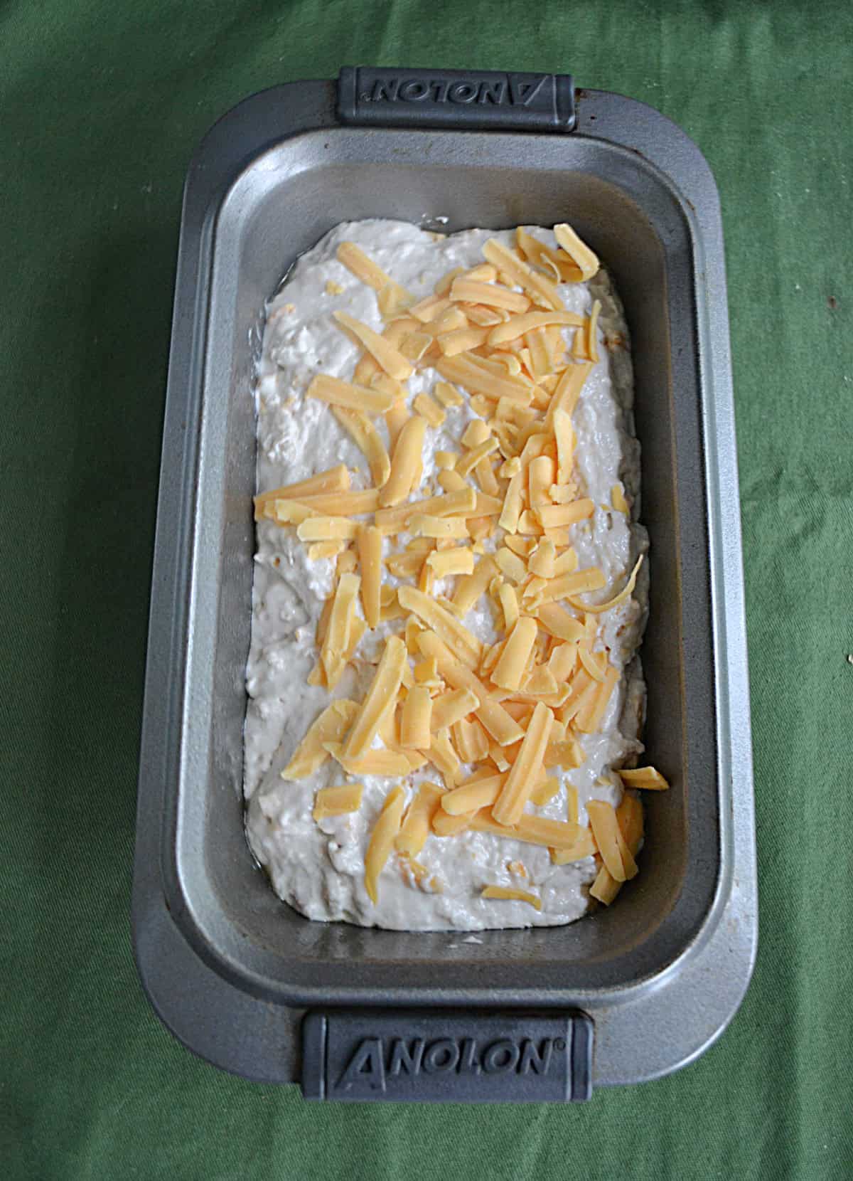 A pan with bread batter and cheese in it.