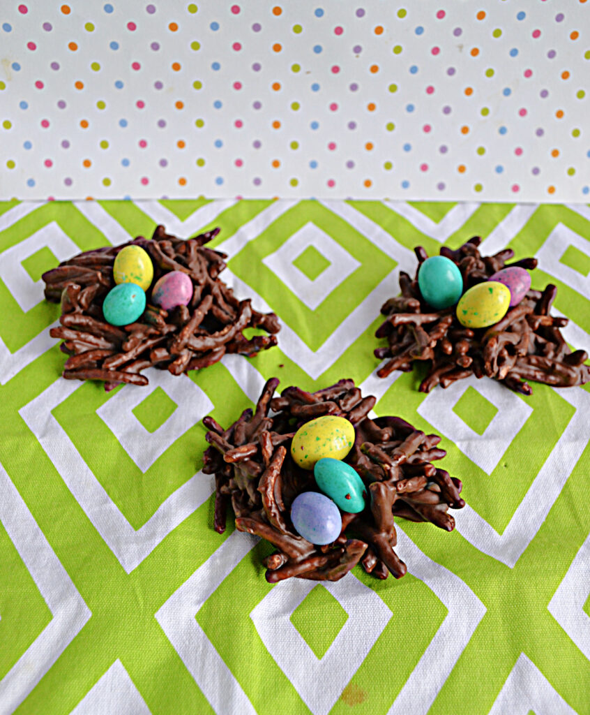 3 chocolate bird's nest cookies with chocolate eggs on top. 