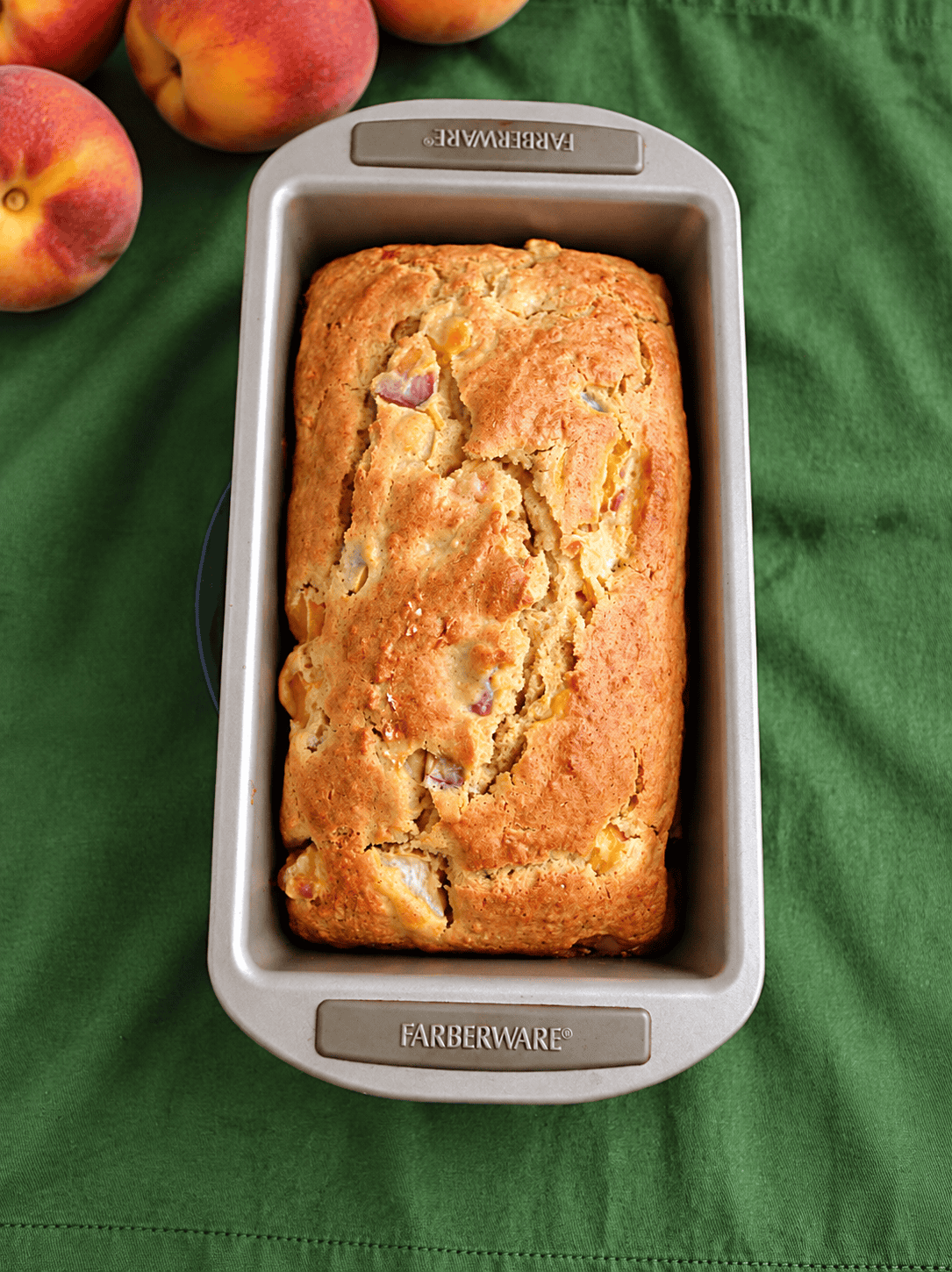 A loaf pan with golden brown bread in it.