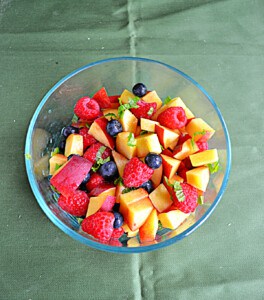 A bowl of berries and peaches.
