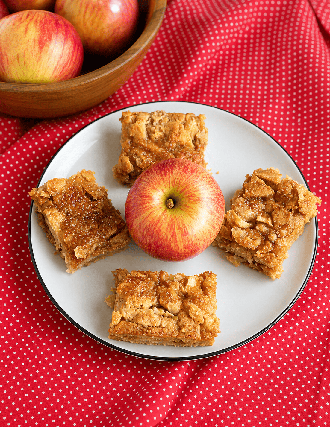 A plate of apple squares with an apple in the middle of them.