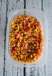 A container of corn and tomato salsa.