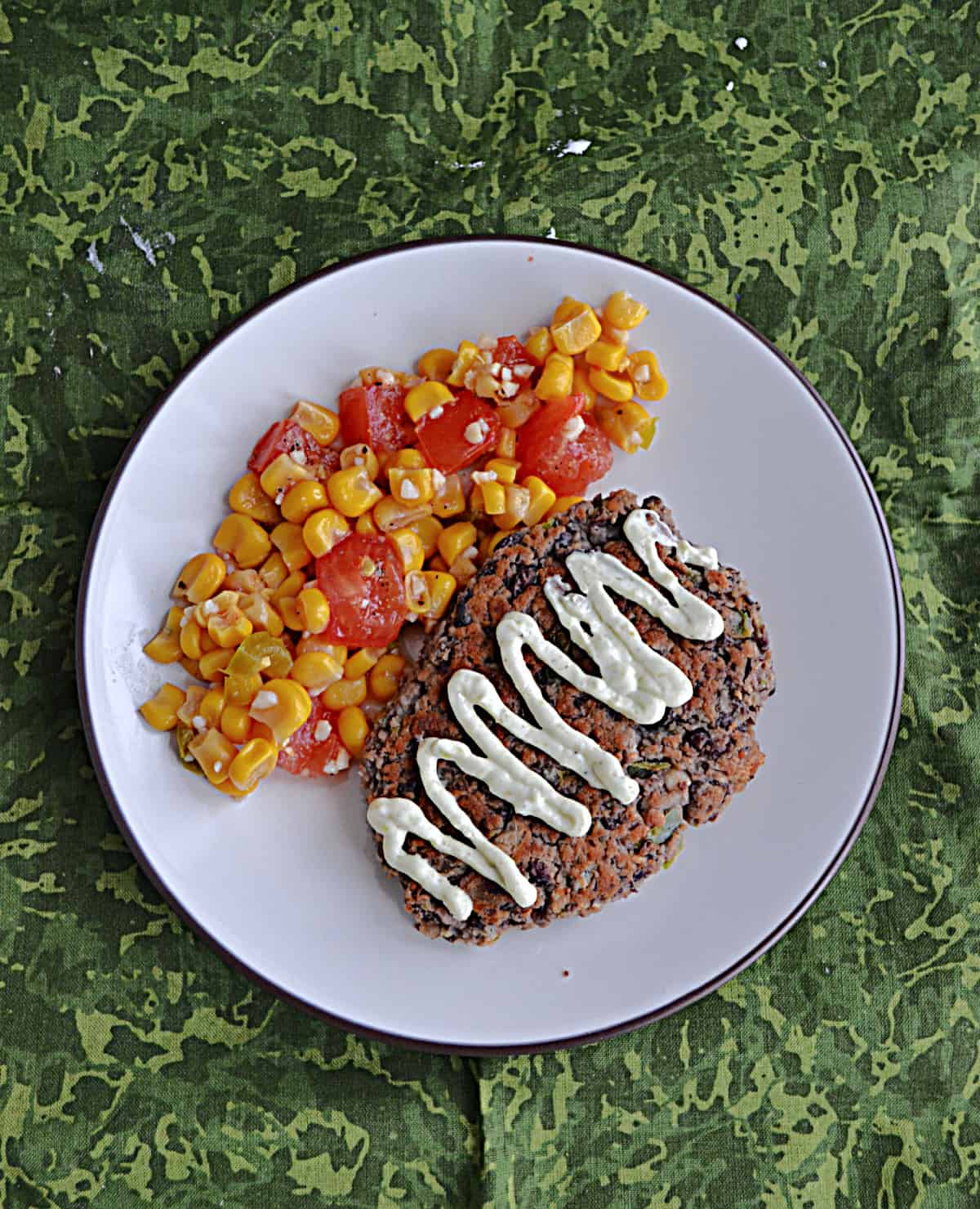 A plate with black bean patties and corn salsa on it.