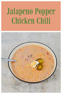 Pin Image: Text, a bowl of Jalapeno Popper Chicken Chili topped with sour cream and jalapeno rings with a spoon in it.