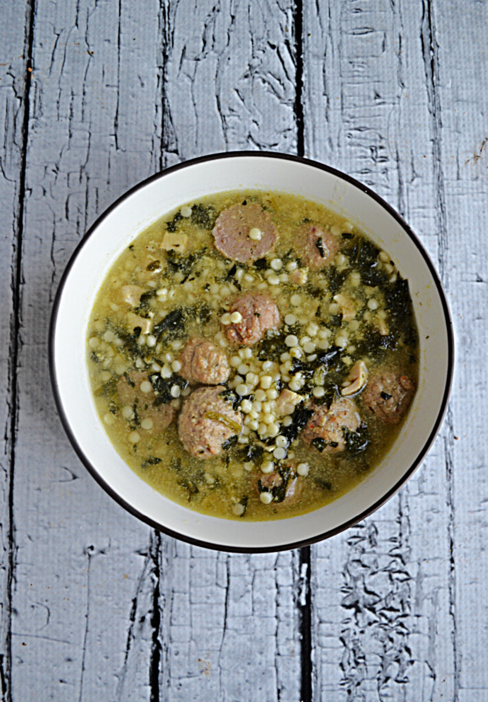 A bowl of Italian Wedding Soup with pasta and meatballs in it. 