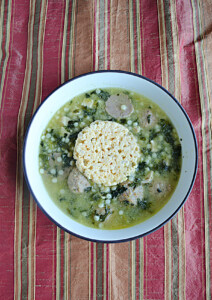 A bowl of Italian Wedding Soup with a cheese crisp in the middle.
