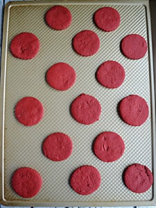 A baking sheet with red velvet shortbread cookies waiting to be baked.