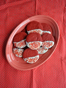 A plate of red velvet shortbread cookies dipped in white chocolate.