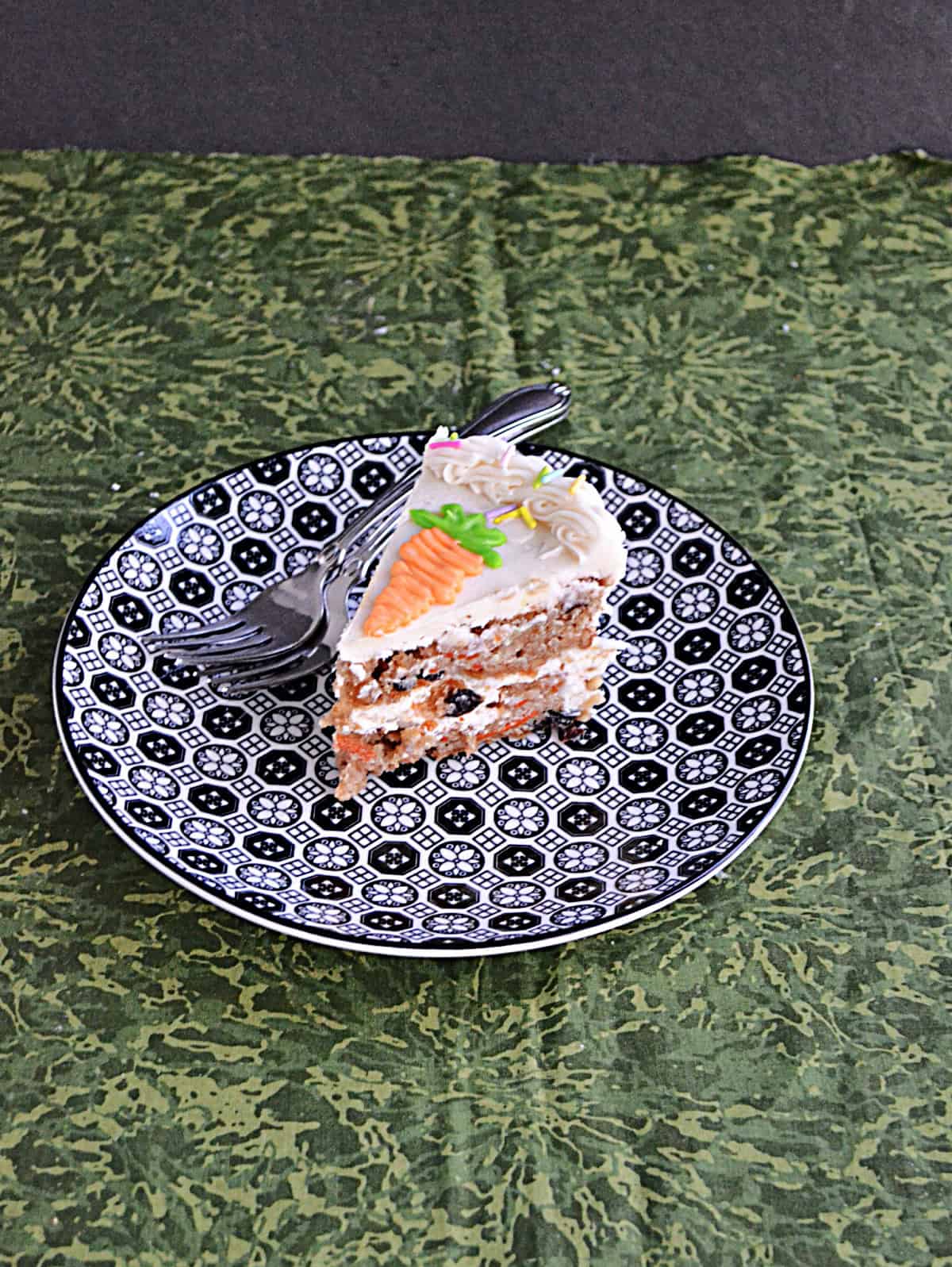 A slice of carrot cake on a plate with a fork. 