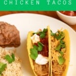 Pin Image: Title, A plate with two tacos, a scoop of rice, a scoop of beans, and a bowl of salsa in the background.