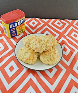 A plate of biscuits with a can of Old Bay seasoning.