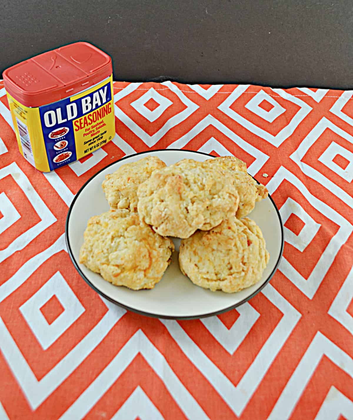 A plate of biscuits with a can of Old Bay seasoning.