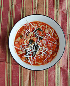 A bowl of Pasta e Fagioli with pasta and beans and Parmesan cheese.