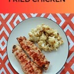 Pin Image: Text title, a plate with two pieces of oven fried chicken and cauliflower on it.