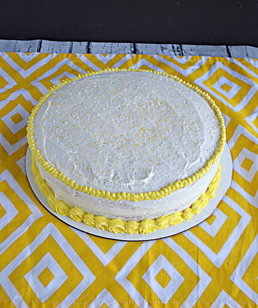 A Lemonade cake with white frosting and yellow piping.
