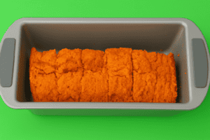 A baking pan with pumpkin cut outs in it.