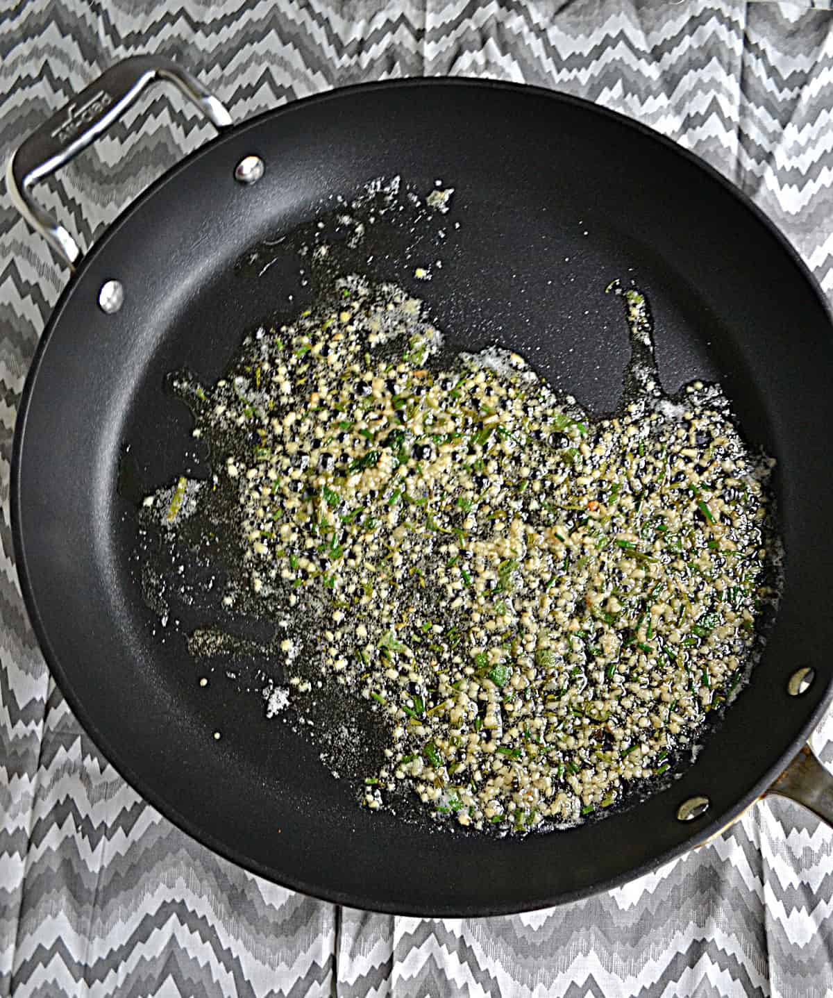 A pan of butter, garlic, and herbs.