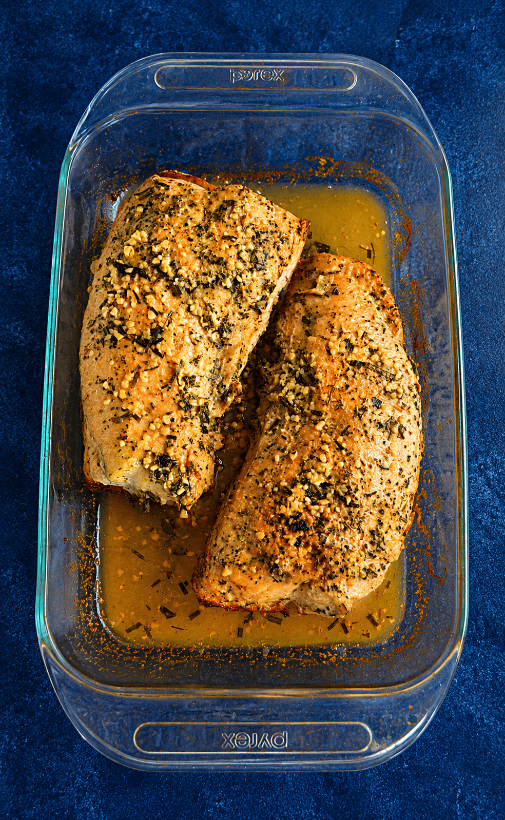 A baking dish with two turkey tenderloins that are golden brown.