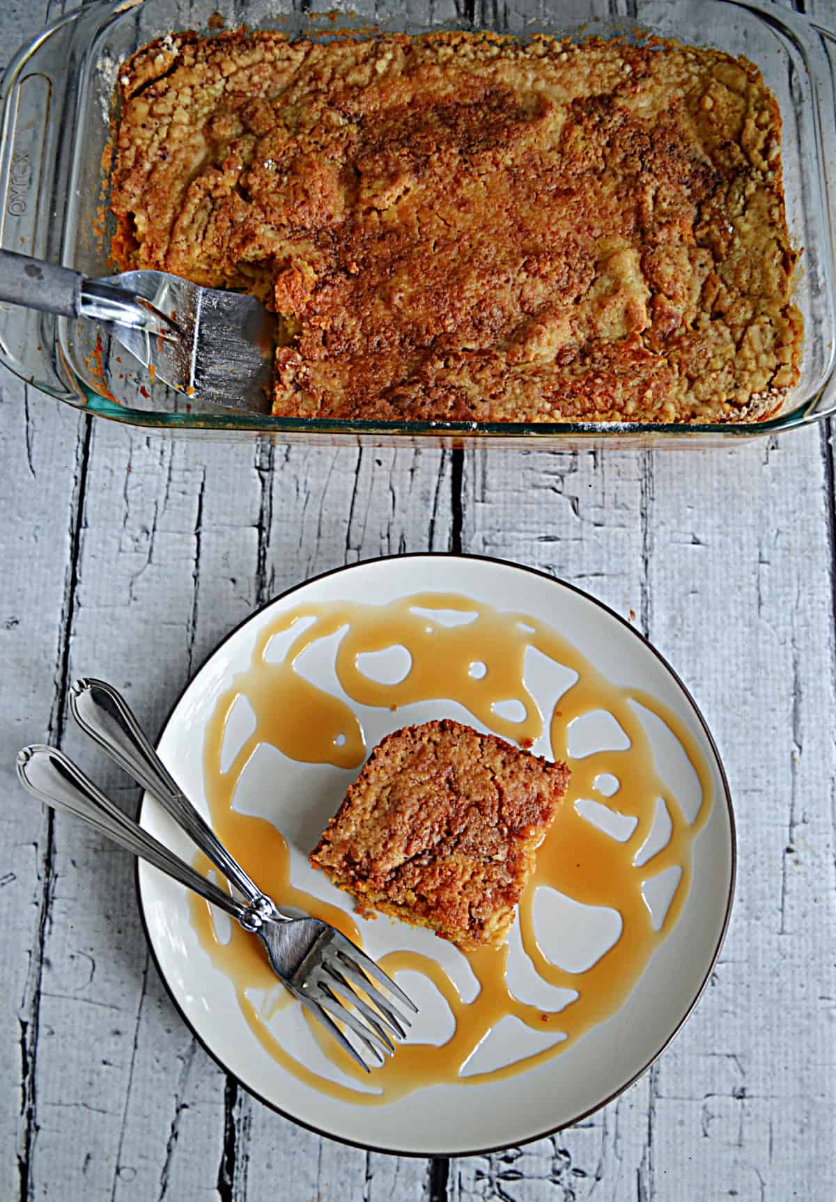 A pan of pumpkin cake with a slice of the cake on a plate with two forks. 