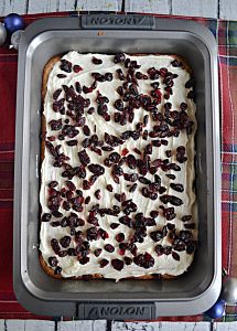 A pan of cranberry bliss bars topped with dried cranberries.