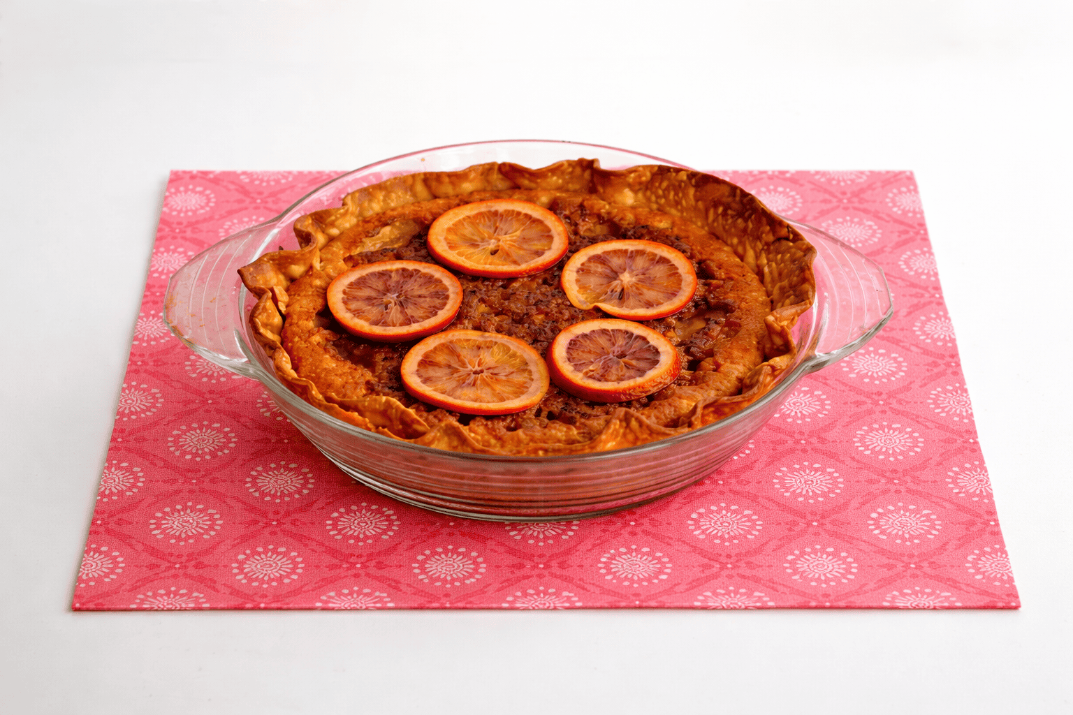 A whole blood orange pie in a pan.