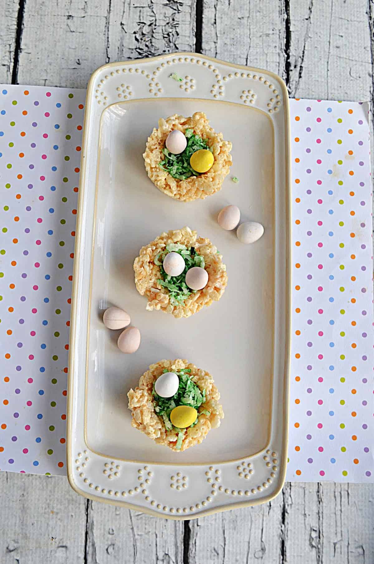 Rice Krispies treats nest with green coconut and candy eggs.
