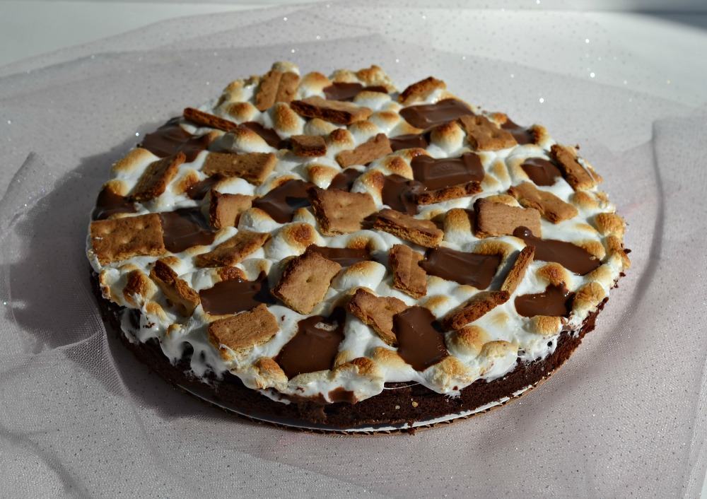 S'mores cake is a delicious chocolate cake topped with marshmallows, graham crackers, and Hershey bar pieces