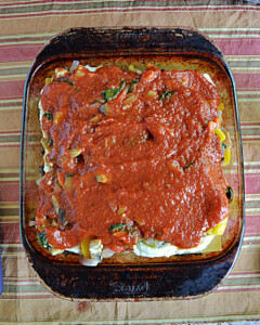 A lasagna topped off with marinara sauce