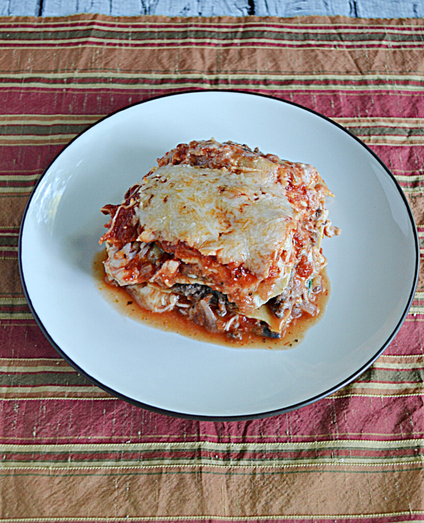 A plate with a large slice of lasagna on it.