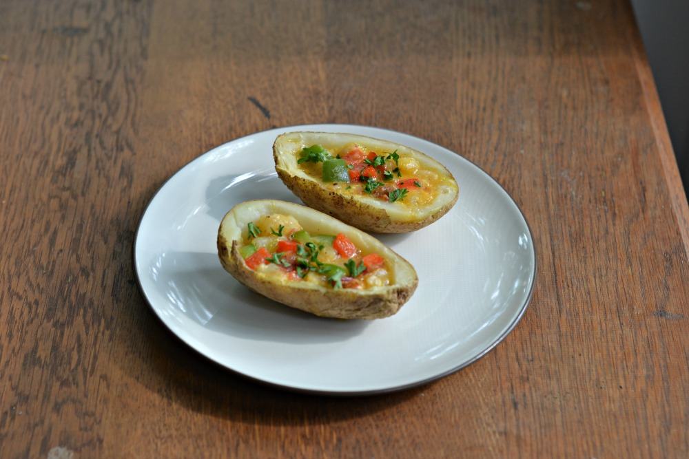 Delicious Omelet Stuffed Breakfast Potatoes made with peppers, bacon, eggs, cheese, and potatoes