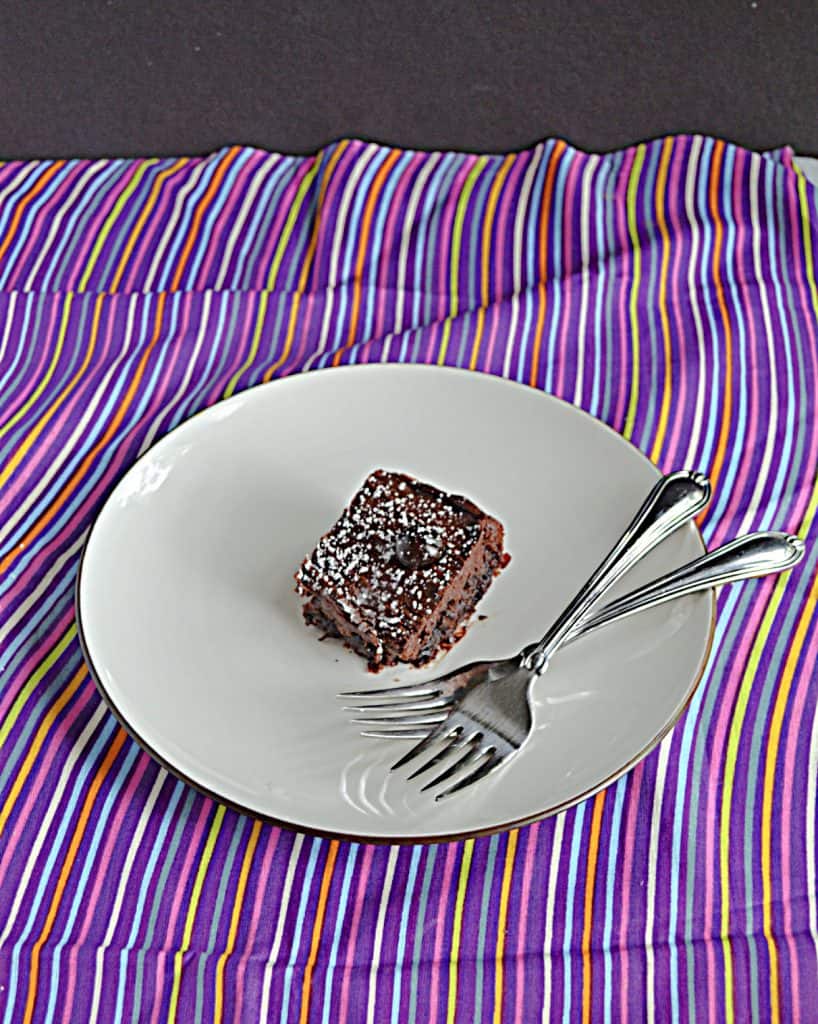 A plate with a Chocolate Cranberry Brownie on it with two forks on the plate.