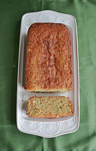A platter with zucchini bread on it and a slice of the bread showing.