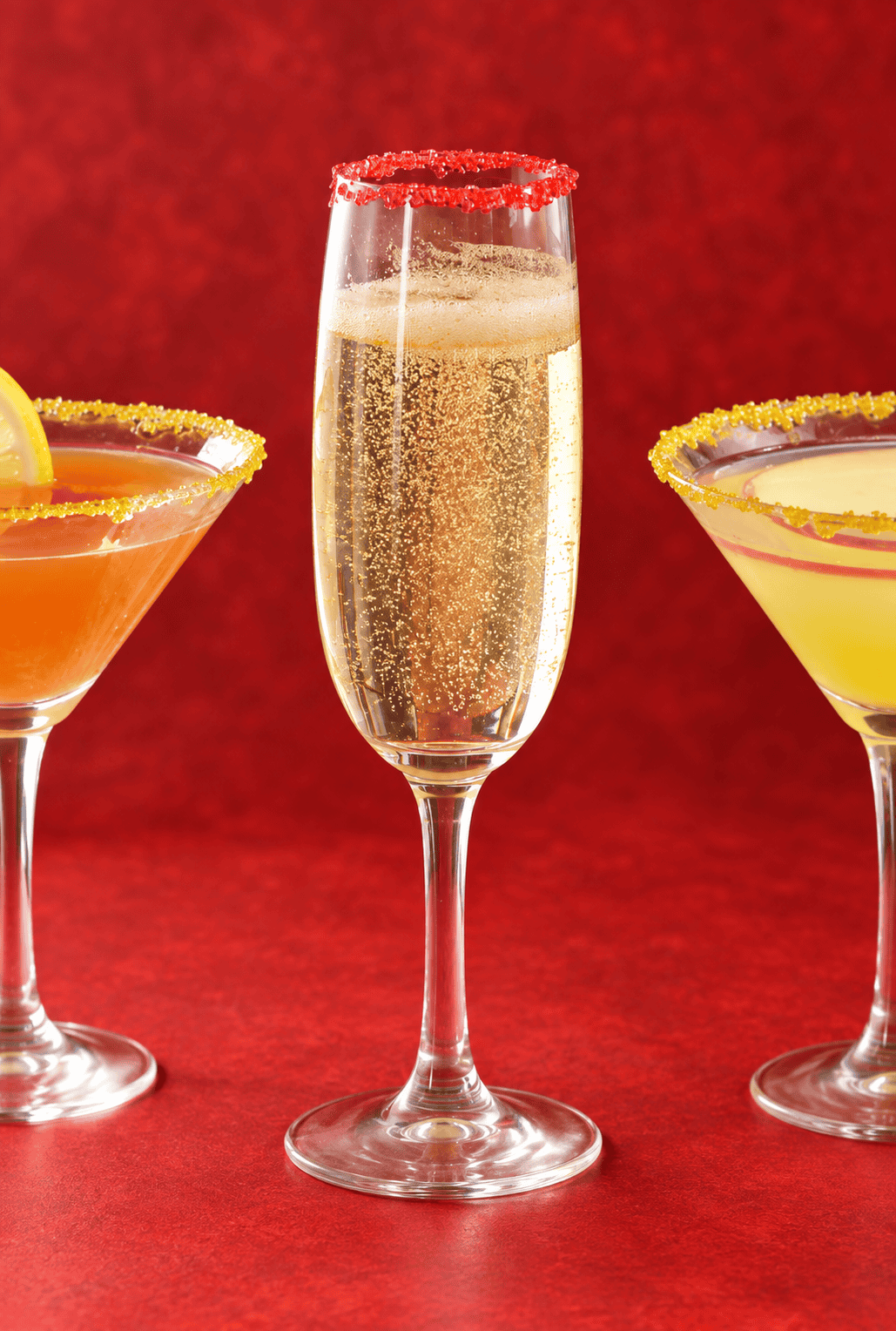 A glass of champagne with two martini glasses on either side.