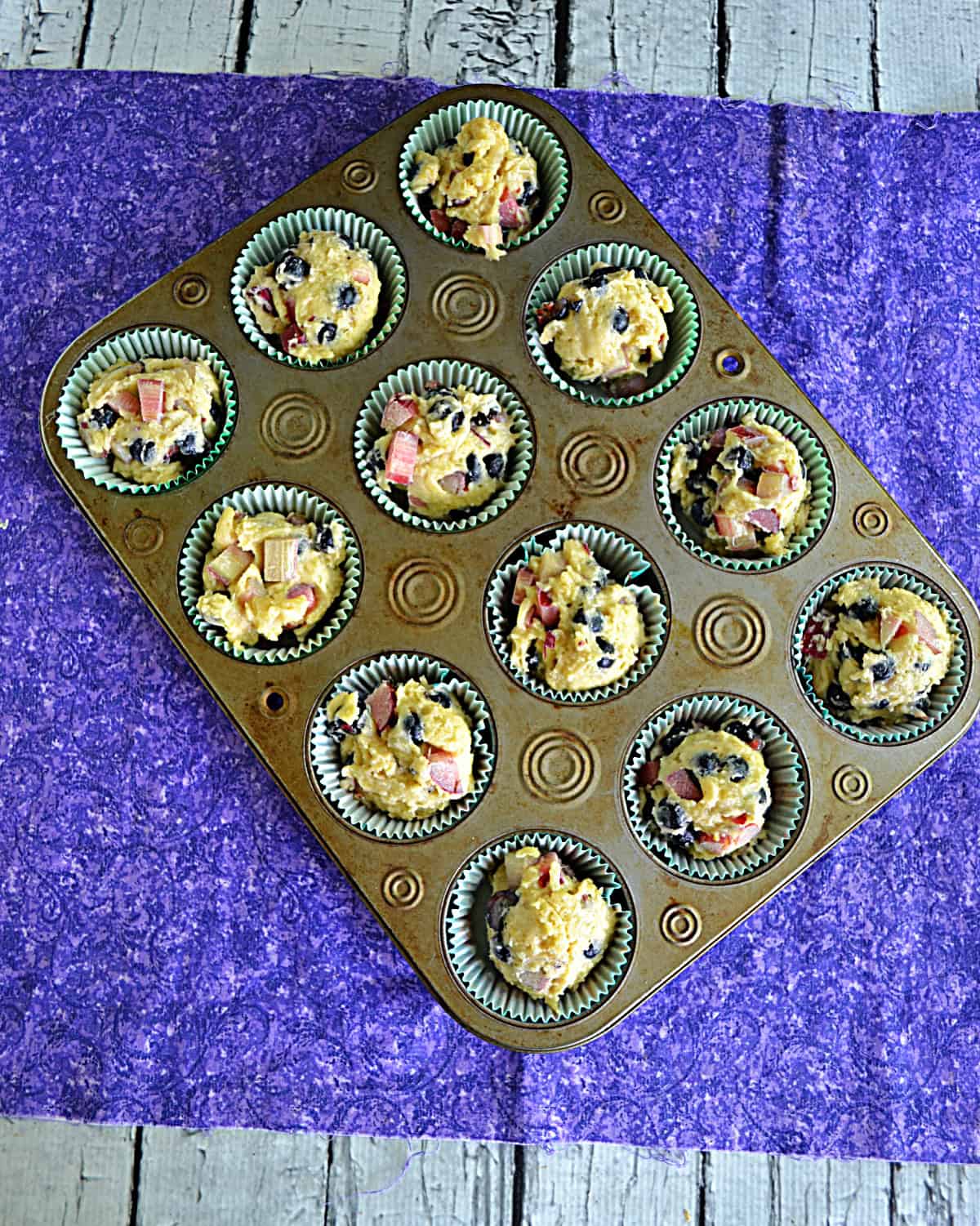 A muffin tin with muffin batter in each cup.