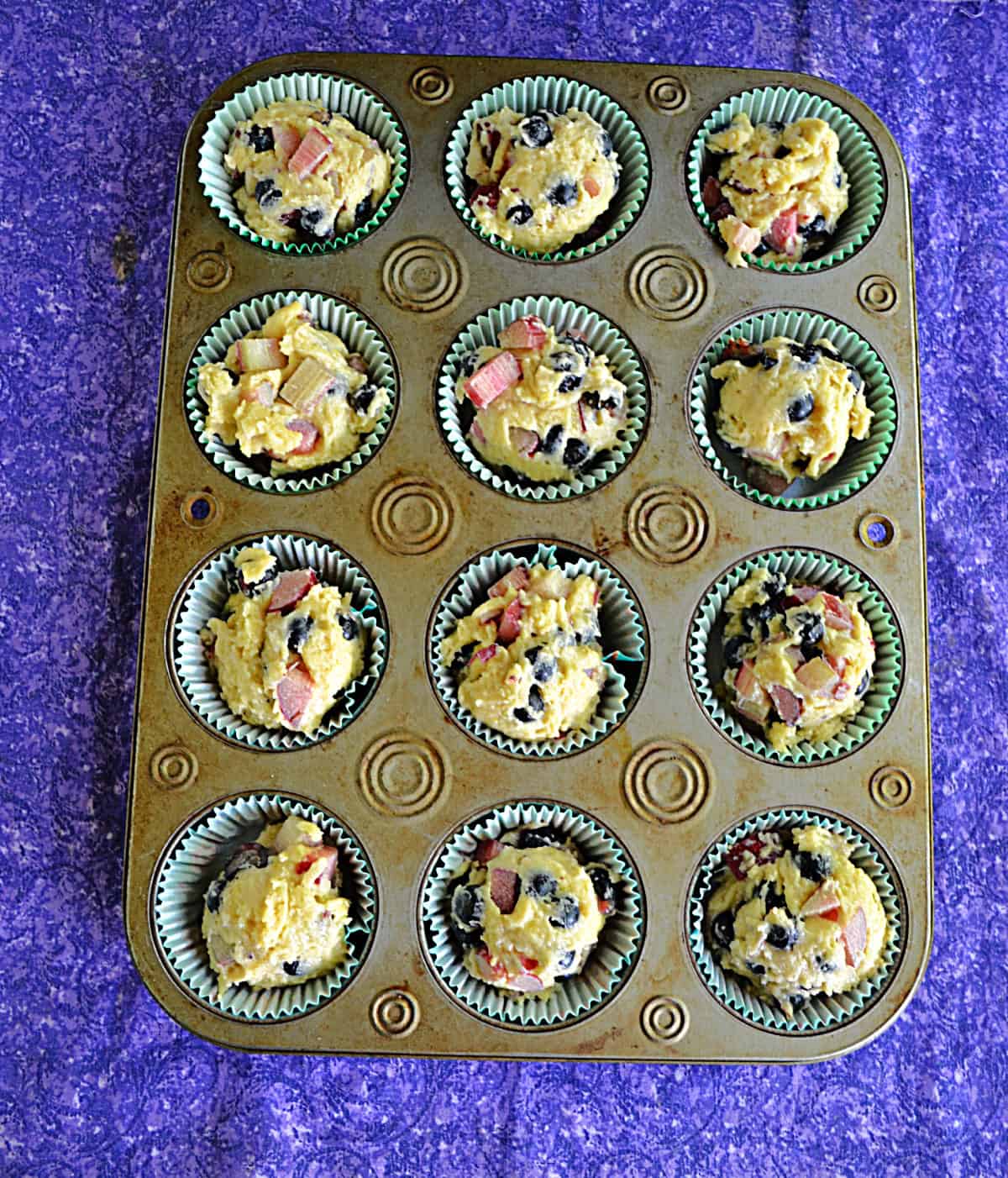 A muffin tin with golden brown muffins in it.