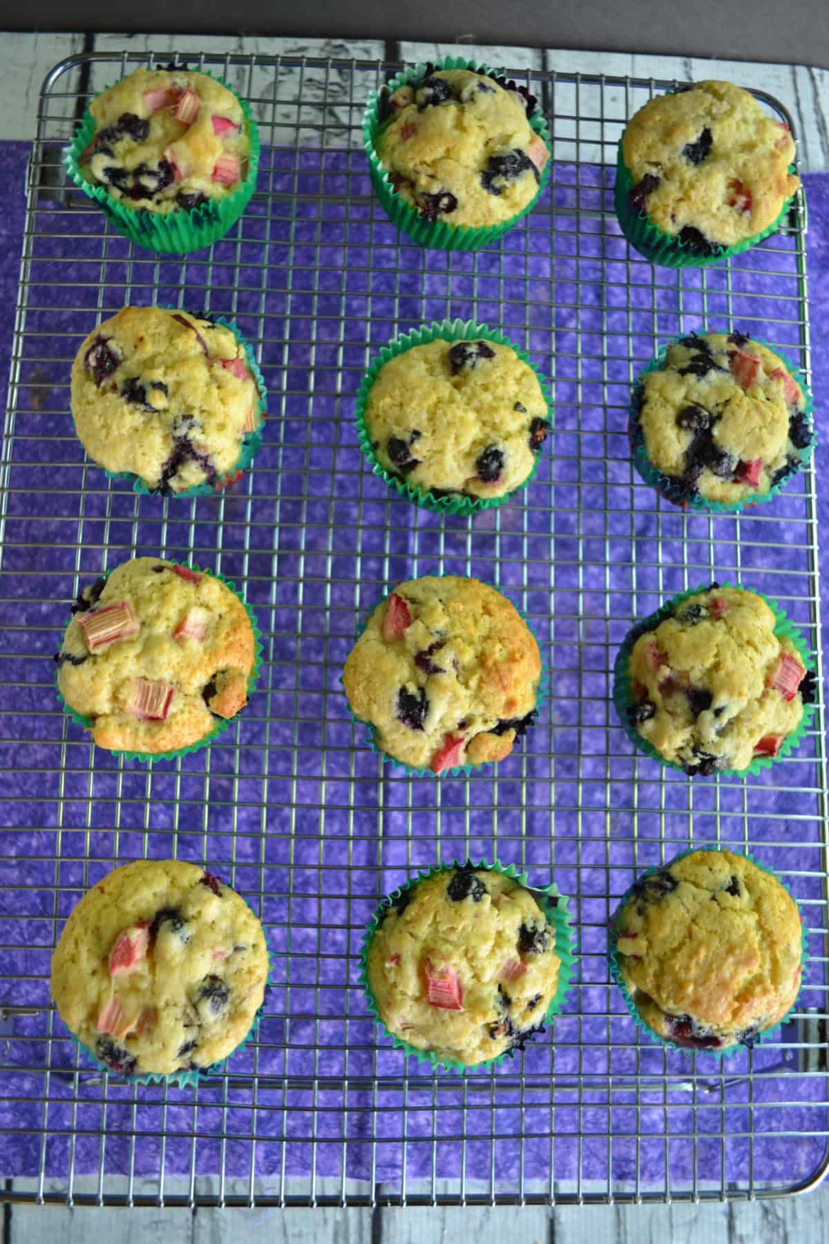 A wire cooling rack with golden brown muffins on it.