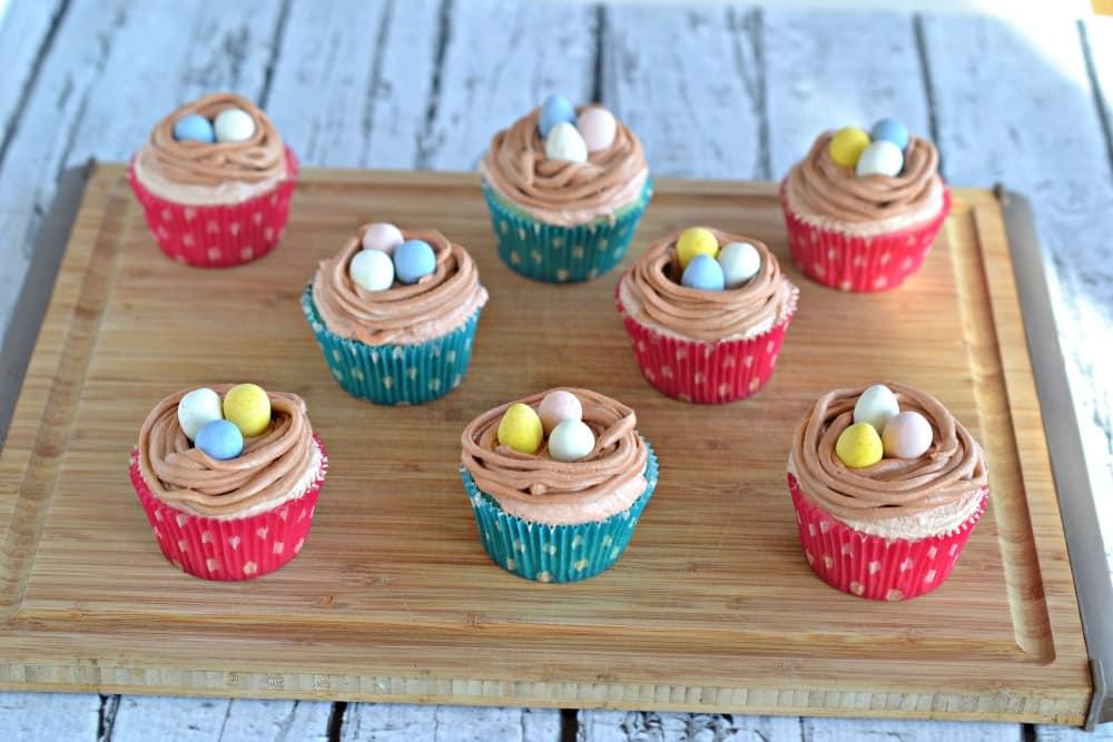 Vanilla cupcakes with brown frosting "nests" topped with chocolate eggs and a PEEPS chick