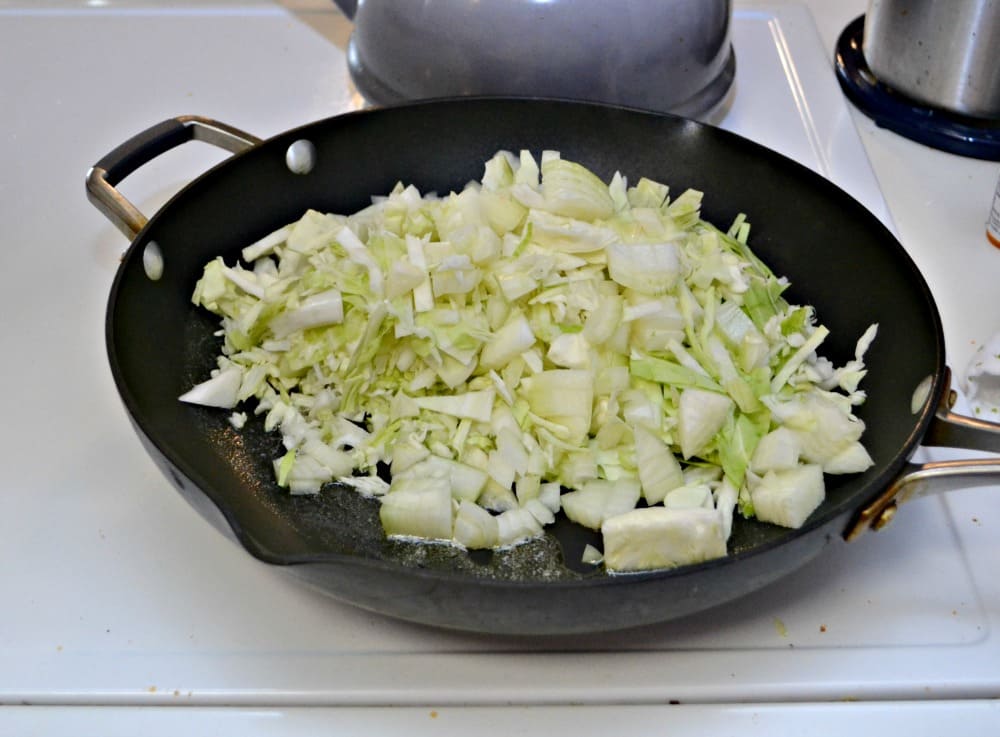 A skillet with cabbage in it. 