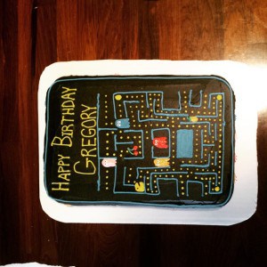 PacMan Cake is chocolate flavored decorated with colored buttercream frosting.