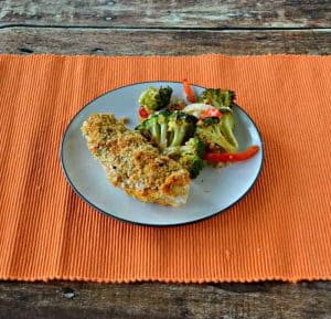 Delicious Hummus Crusted Chicken served with a side of roasted vegetables