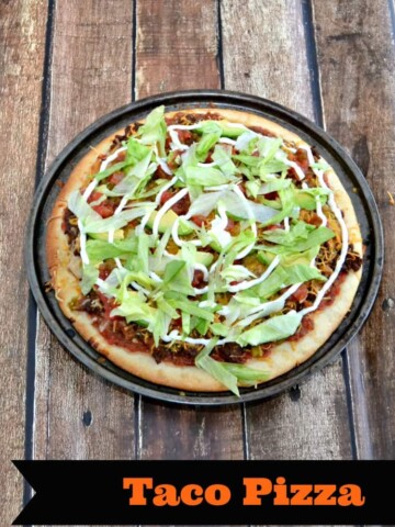 Tasty Taco Pizza layered with your favorite taco topping like seasoned ground beef, cheese, refried beans, lettuce, sour cream, and more!