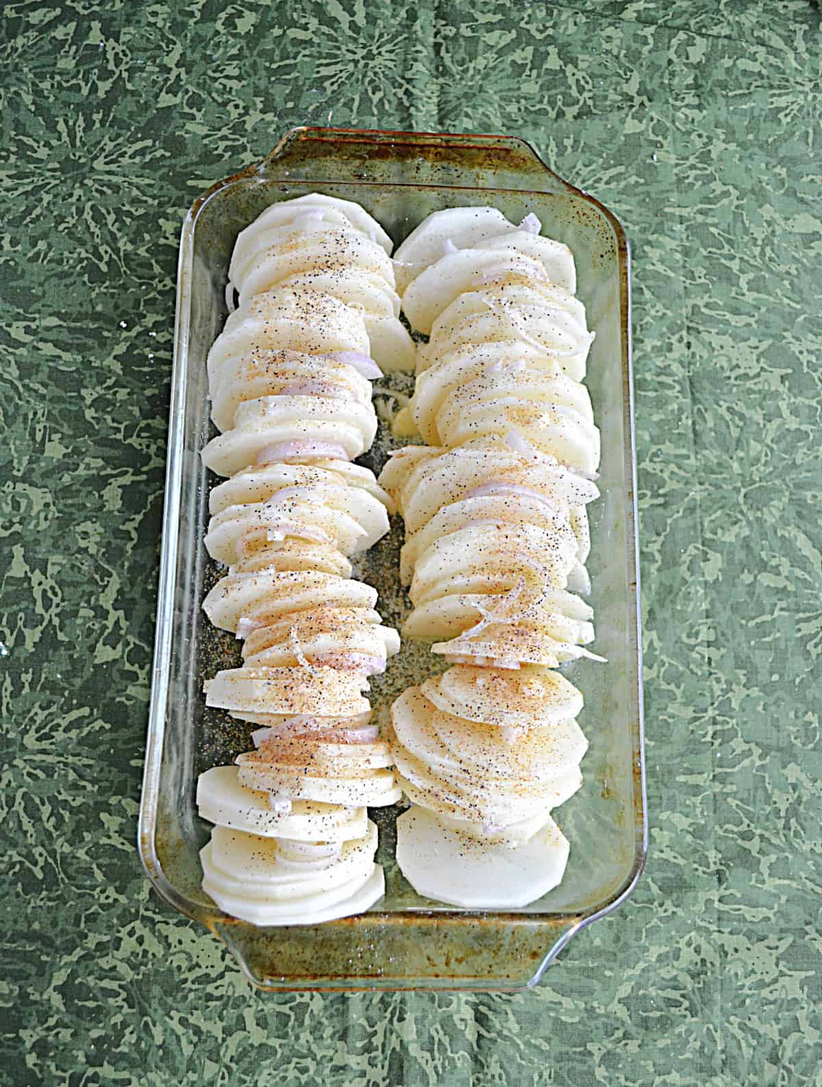 A baking dish with sliced potatoes.