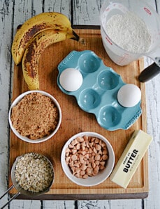 A cutting board with ingredients for the banana bread on it.